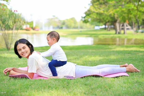 Счастливая Азиатская Мать Играет Своим Сыном Лежит Зеленой Лужайке Парке — стоковое фото