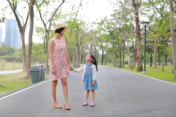 屋外の自然の庭で手をつないでお母さんと娘 — ストック写真