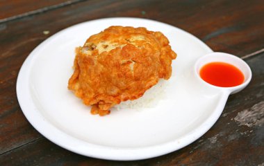 Bir omlet, bir kızartma tavasında hızlı bir şekilde tereyağı veya yağ ile pişmiş dövülmüş yumurtadan yapılmış bir yemeğidir. Tay tarzı fast food plaka üzerinde buharda pirinç ve biber sos ile servis.