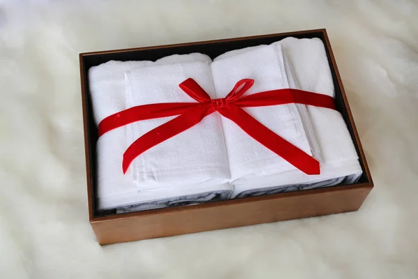 White towel gift in leather box on artificial fur background