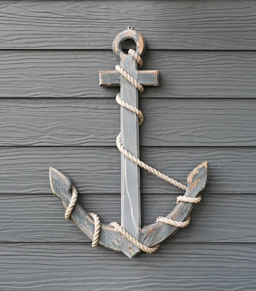 Wooden anchor with rope on wood plank wall background