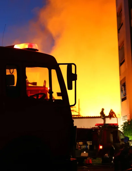 燃えている家 消防士が火を消すしようとしています — ストック写真