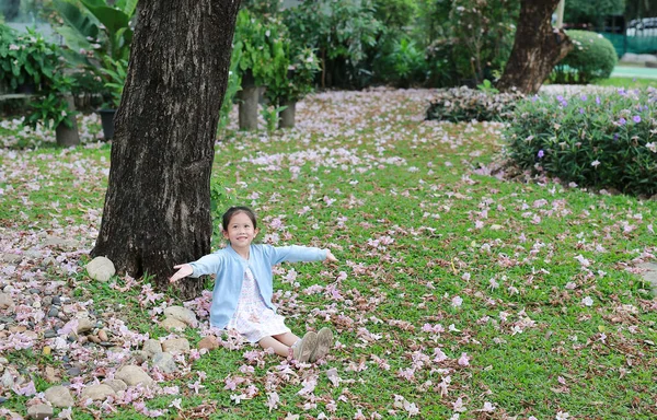 Sorrindo Pequena Menina Asiática Sentada Grama Verde Sob Tronco Árvore — Fotografia de Stock