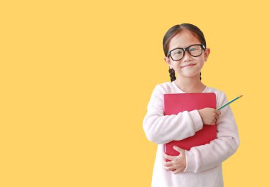 Asyalı kız öğrenci gözlük sarılma bir kitap giyen ve kalem tutan 