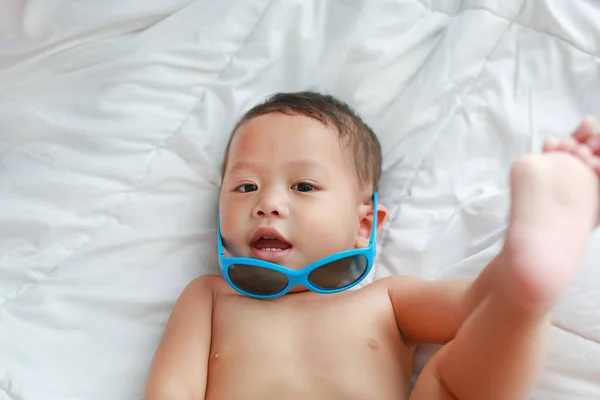 Śmieszne Trochę Asian Baby Boy Okulary Leżącego Białym Kocu Łóżku — Zdjęcie stockowe