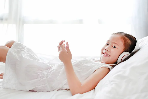 Šťastná Malá Asijská Dívka Používající Sluchátka Naslouchají Sluchátky Když Telefon — Stock fotografie