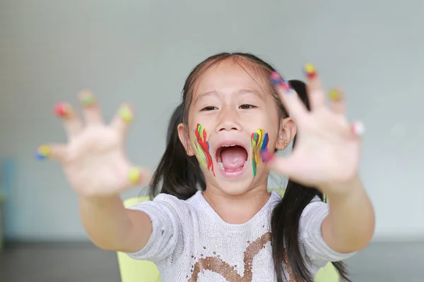 Portrait Smiling Little Girl Looking Her Colorful Hands Cheek Painted — Stock Photo, Image