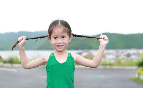 Szczęśliwy Mało Asian Dziecko Dziewczyna Górski Pole Trzyma Jej Warkocze — Zdjęcie stockowe