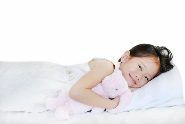 Porträt eines süßen lächelnden kleinen asiatischen Mädchens, das im Bett liegt. — Stockfoto