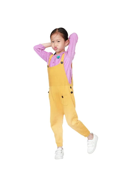 Śmieszne twarz trochę Asian Girl w różowe żółte spodnie ogrodniczki stwarza touc — Zdjęcie stockowe