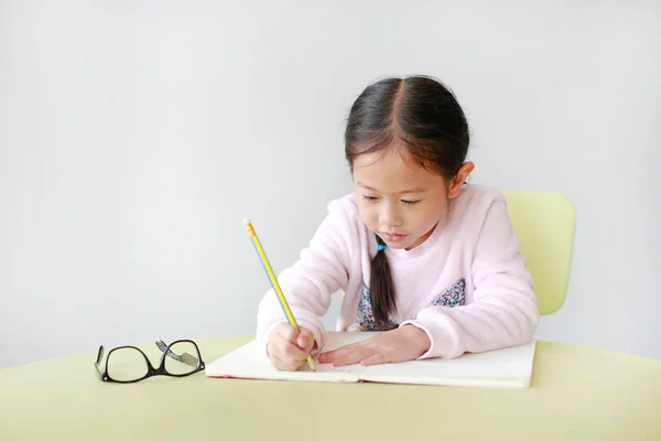 Retrato Sorridente Menina Asiática Escreve Livro Caderno Com Lápis Mesa — Fotografia de Stock