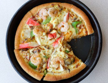 Tabak içinde deniz ürünleri pizza