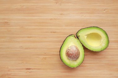 Copy alanı ile ahşap tahta arka planda ikiye kesilmiş Closeup Avokado.