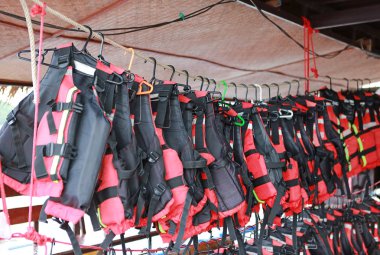 Turuncu renkli can yelekleri tekne istasyonunda satır asılı.