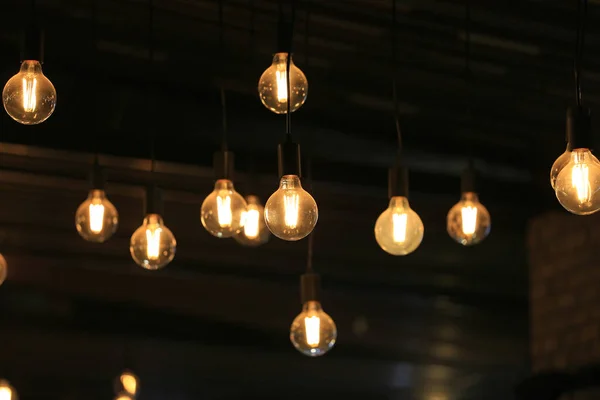Vintage glowing light bulbs hanging. Decorative antique style light bulbs.