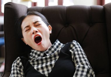 Kütüphanede uykulu genç Asyalı kadın.