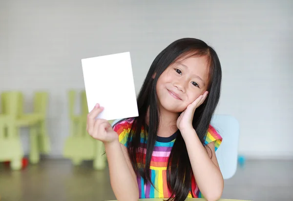 Söt Liten Leende Asiatisk Barnflicka Som Håller Blankt Vitt Papper — Stockfoto