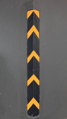 Açı beton duvarda siyah ve sarı trafik uyarısı