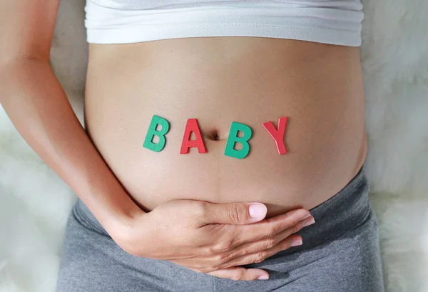 Närbild Gravid Kvinna Sitter Mjuk Soffa Och Vidrör Hennes Mage — Stockfoto