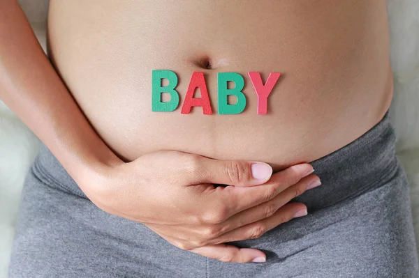 Närbild Gravid Kvinna Sitter Mjuk Soffa Och Vidrör Hennes Mage — Stockfoto