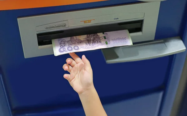 Child hand receive money from ATM