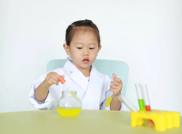 Asian child in scientist uniform holding test tube with liquid, Scientist chemistry and science education concept.