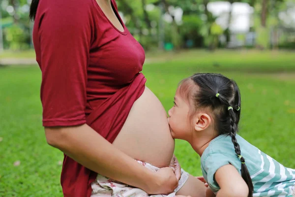 Menina Bonita Abraçando Barriga Uma Mãe Grávida Beijando Jardim — Fotografia de Stock