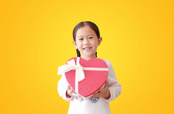 Menina Asiática Segurando Caixa Presente Coração Vermelho Isolado Fundo Amarelo — Fotografia de Stock