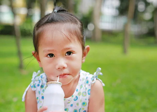 一个小女孩在公园里用稻草喝牛奶的画像 户外肖像 — 图库照片