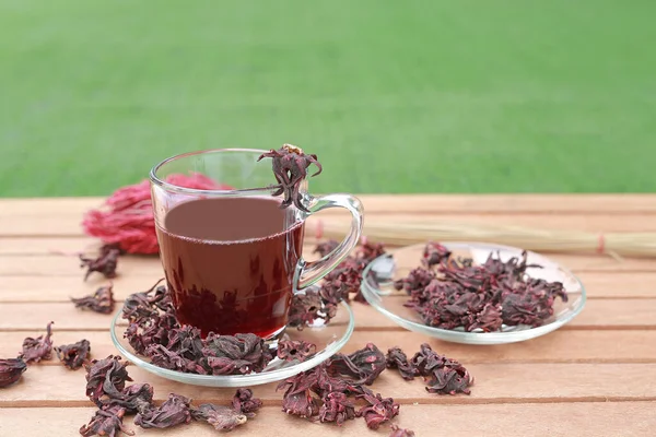 Roselljuice Kopp Och Torr Roselle Träplanka Mot Grönt Gräs Bakgrund — Stockfoto