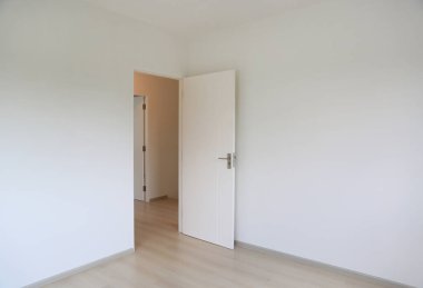 Yeni evin beyaz odasında açık bir kapı.