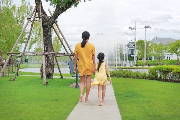 母親と娘の手の後ろに手を屋外の庭で歩くリラックス 夏の公園で一緒に過ごすママと子供 — ストック写真