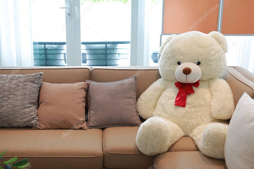 Fabric sofa with big bear doll in living room