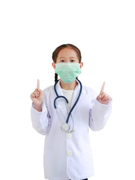 ポートレートアジアの小さな子供の女の子で医師の制服とともに聴診器と身に着けている医療マスクショー二つの前指分離上の白の背景 ストック画像