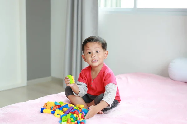 Азиатский Мальчик Играет Красочные Пластиковые Блоки Лежит Кровати — стоковое фото
