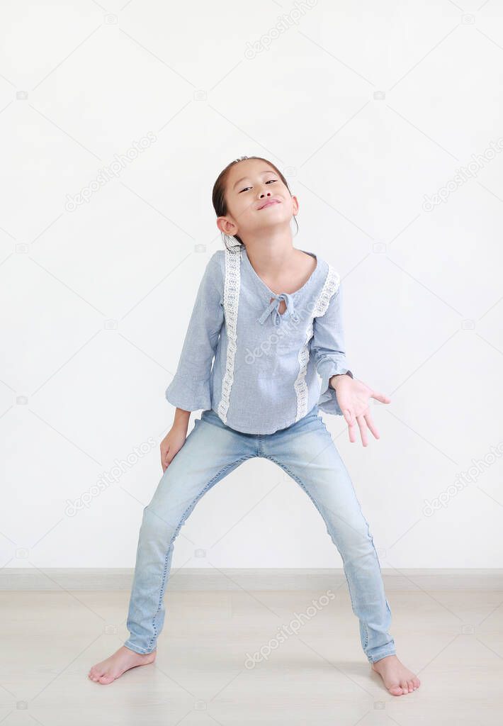 Funny face expression asian little child girl in white room. Full length.