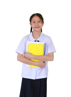 Portrait Asian student girl in school uniform holding a yellow books while standing isolated on white studio background. Schoolgirl back to school concept.