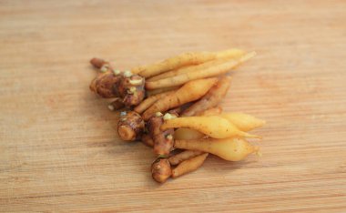 Bambu ahşap zemin üzerinde parmak kökü veya Çin zencefili, pişirme için hazırlık süreci.
