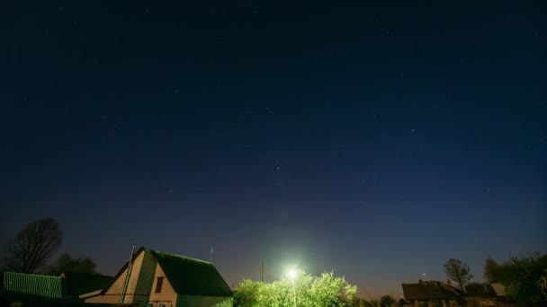 Ночной звездный фон над деревенскими домами. Ночной вид естественных звезд — стоковое видео