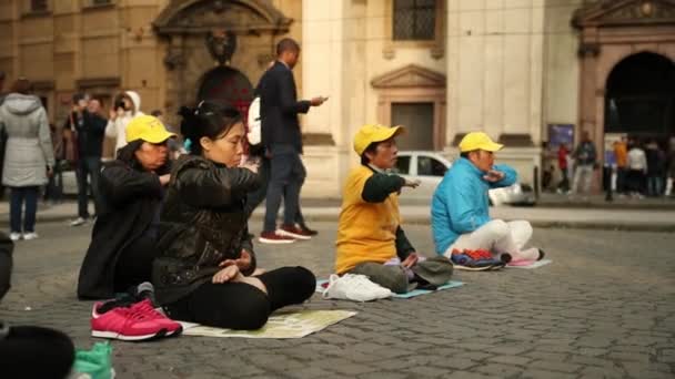 Praga, Repubblica Ceca - 23 settembre 2017: I cinesi sono impegnati nella meditazione Falun Gong o Falun Dafa sulla strada della città — Video Stock