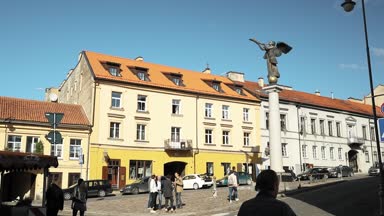 Vilnius, Litvanya - 29 Eylül 2017: Uzupis Bölgesi 'nde Sunny Summer Sky' da Melek Üfleyen Melek Heykeli 'nin yakınında yürüyen insanlar. Uzupio Cumhuriyeti Kültürel Sanatsal Bir Bölgedir
