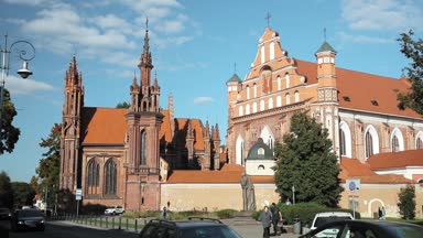 Vilnius, Litvanya. Aziz Anne Katolik Kilisesi, Aziz Francis Kilisesi ve St. Bernard Kilisesi 'nin yanında yürüyen insanlar Yazın güneşli bir günde eski bir kasabada.