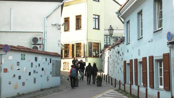 Vilnius, Litva - 29. září 2017: People Walking near Literatu Street - One of The Oldest Streets In The Old Town of Vilnius, Lithuania. Stěna literárních uměleckých děl. Literatu Street Wall — Stock video