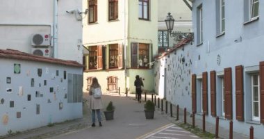Vilnius, Litvanya - 29 Eylül 2017: Literatu Caddesi yakınlarında yürüyen insanlar - Litvanya 'nın Vilnius kentindeki en eski sokaklardan biri. Wall Literary Works of Art. Literatu Sokağı Duvarı