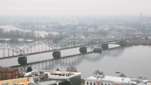 Riga, Lettonia. Vista dall'alto del ponte ferroviario attraverso Daugava o il fiume Dvina occidentale in nebbia nebbia giorno piovoso — Video Stock