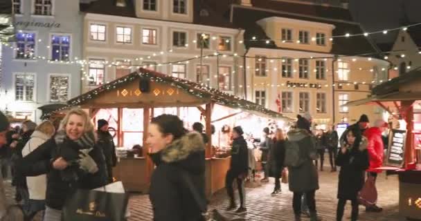 Tallinn, Estonie - 21 décembre 2017 : Des gens marchent dans le marché traditionnel de Noël sur la place de l'hôtel de ville. Maisons de négoce en soirée d'hiver — Video