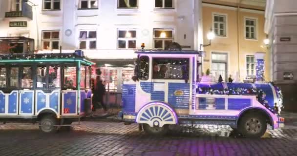 Tallinn, Estland - 21. Dezember 2017: Urlaubsreisende mit dem dekorativen Zug zur Besichtigung des Rathausplatzes — Stockvideo