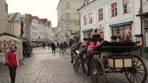 Tallinn, Estland - 22. Dezember 2017: Menschen reisen in altmodischen Reisebussen an der Old Town Street — Stockvideo