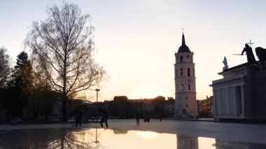 Vilnius, Litvanya. St. Stanislaus Katedral Bazilikası yakınlarındaki Katedral Meydanı ve ilkbahar günbatımı güneşli akşamında çan kulesi olan St. Vladislav. Zaman Hızlandırılmış Zaman HızlandırmasıComment