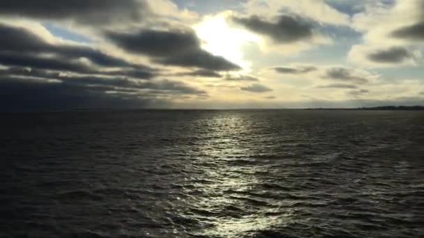 El sol brilla a través de nubes pesadas sobre el mar Báltico en el día de invierno. Movimiento flotante sobre el mar — Vídeos de Stock